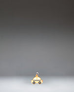 Herschel Taxi Bag Charm in Taxi, a yellow checker-cab-inspired miniature bag accessory with black and white checkered details.